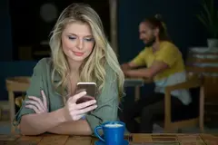 Attractive woman looking at her phone in a cafe