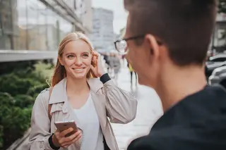 Young couple laughing and meeting in a big city street