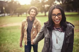 Smiling couple holding hands out for a walk in the park in spring