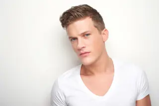 Gay man in a white T-shirt looking into the camera