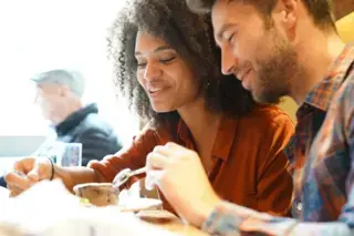 Happy couple on a date eating cake