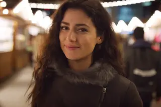 Portrait of smiling brunette woman standing at Christmas market