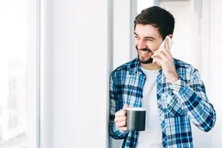 Man with coffee chatting on mobile phone