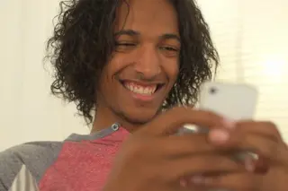 Young man smiling while texting on his phone