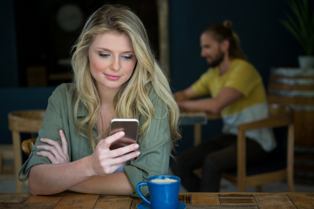 Attractive woman looking at her phone in a cafe