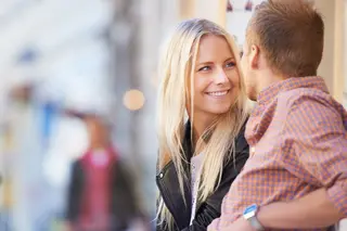 A young couple having a conversation on a bench in the street